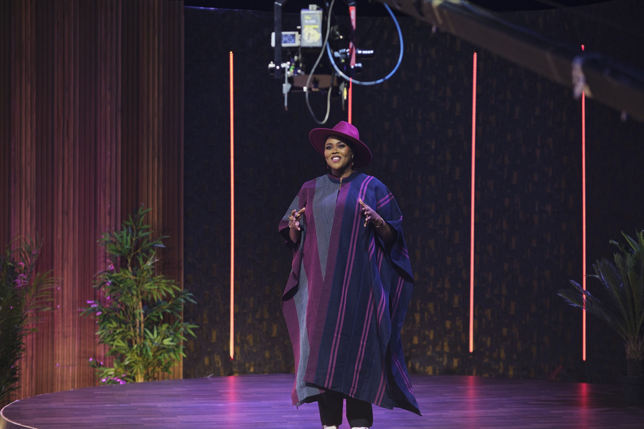 Abosede George-Ogan on a studio stage in a burgundy hat